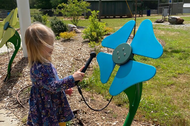 Girl Playing a musical flower In The Rotary Children's Music Park